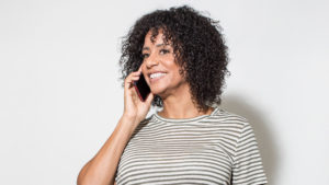 woman in striped shirt talking on smartphone